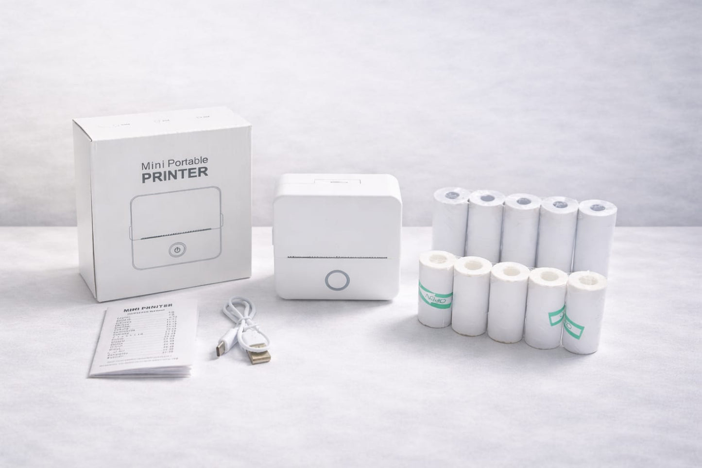 Package includes:

Printer
Charger
User manual
5 rolls sticker paper
5 rolls white paper